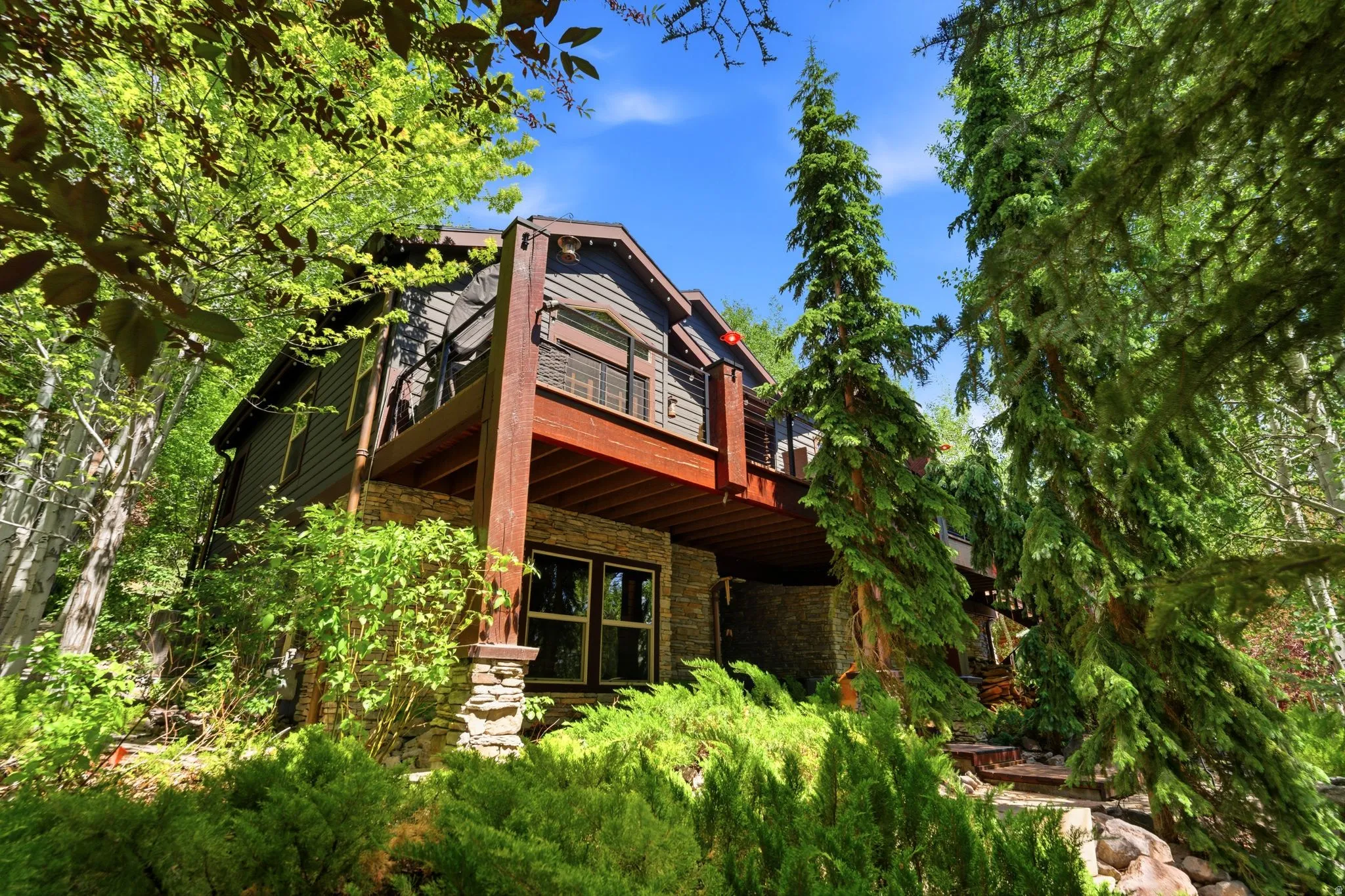 Multi-level residence featuring a stone foundation and wood siding
