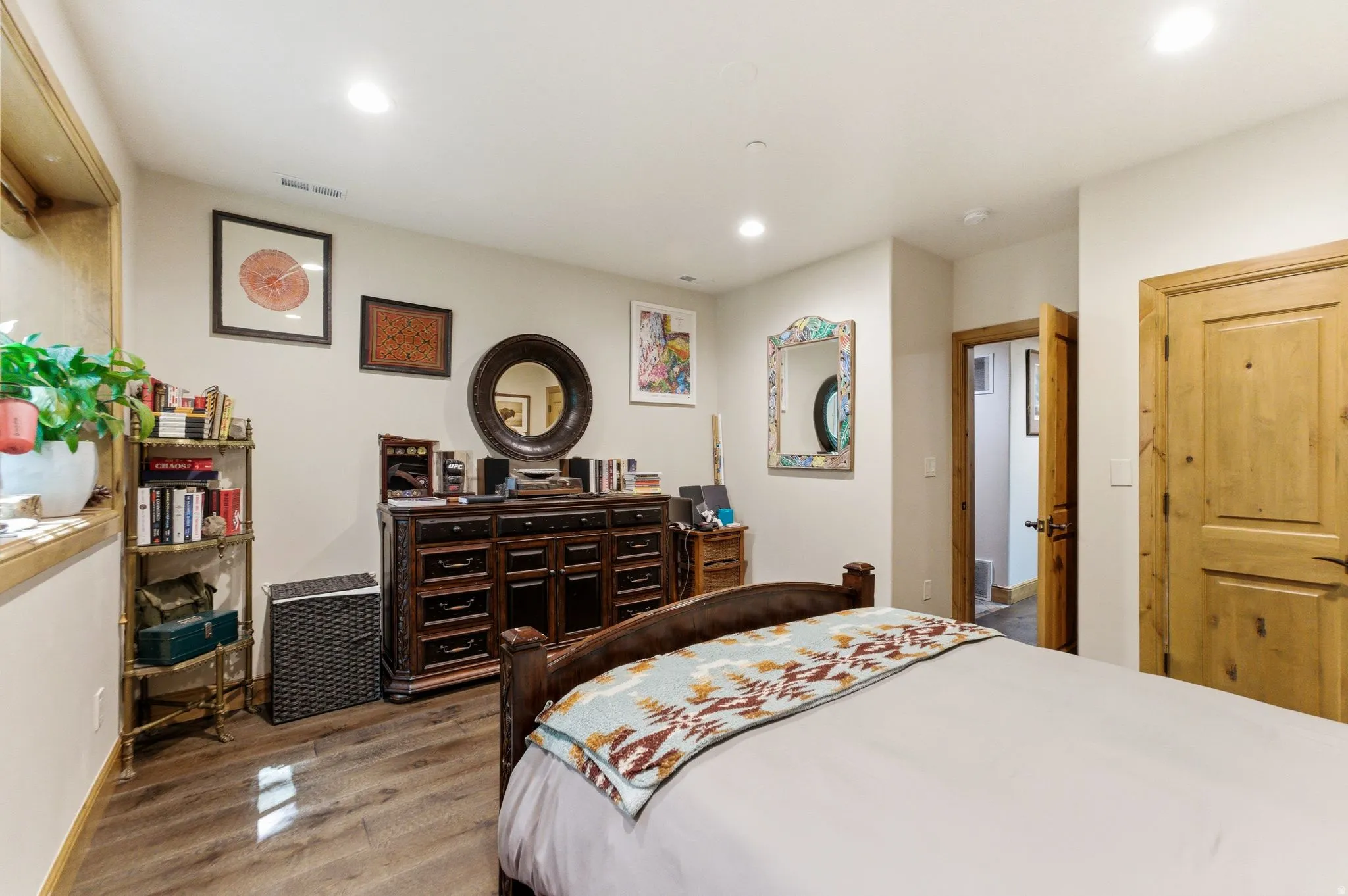 Bedroom featuring wood-finish flooring, recessed lighting, and a solid wood door with dark hardware