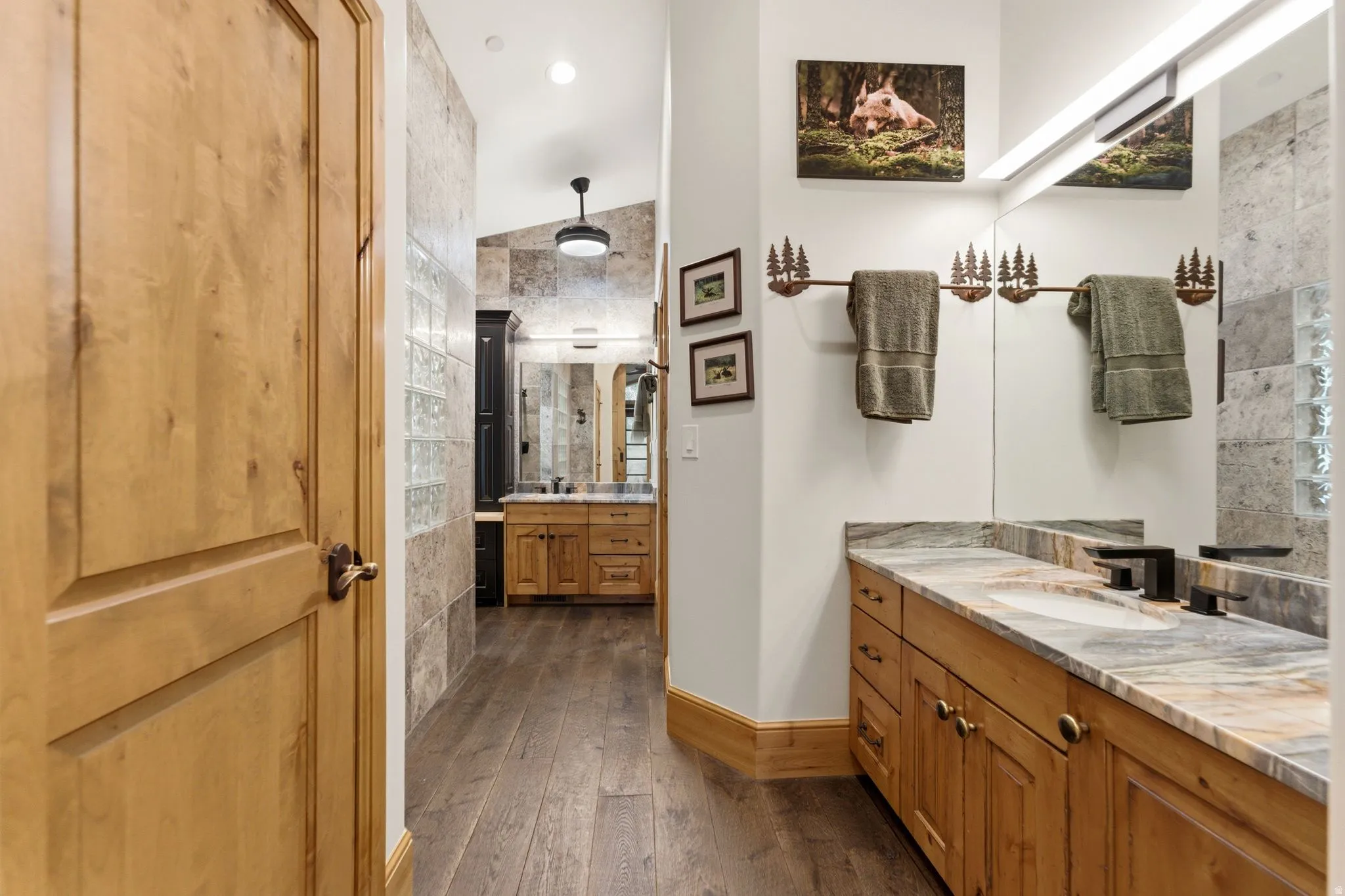 Double vanity featuring stone countertops and integrated sinks with matte black fixtures
