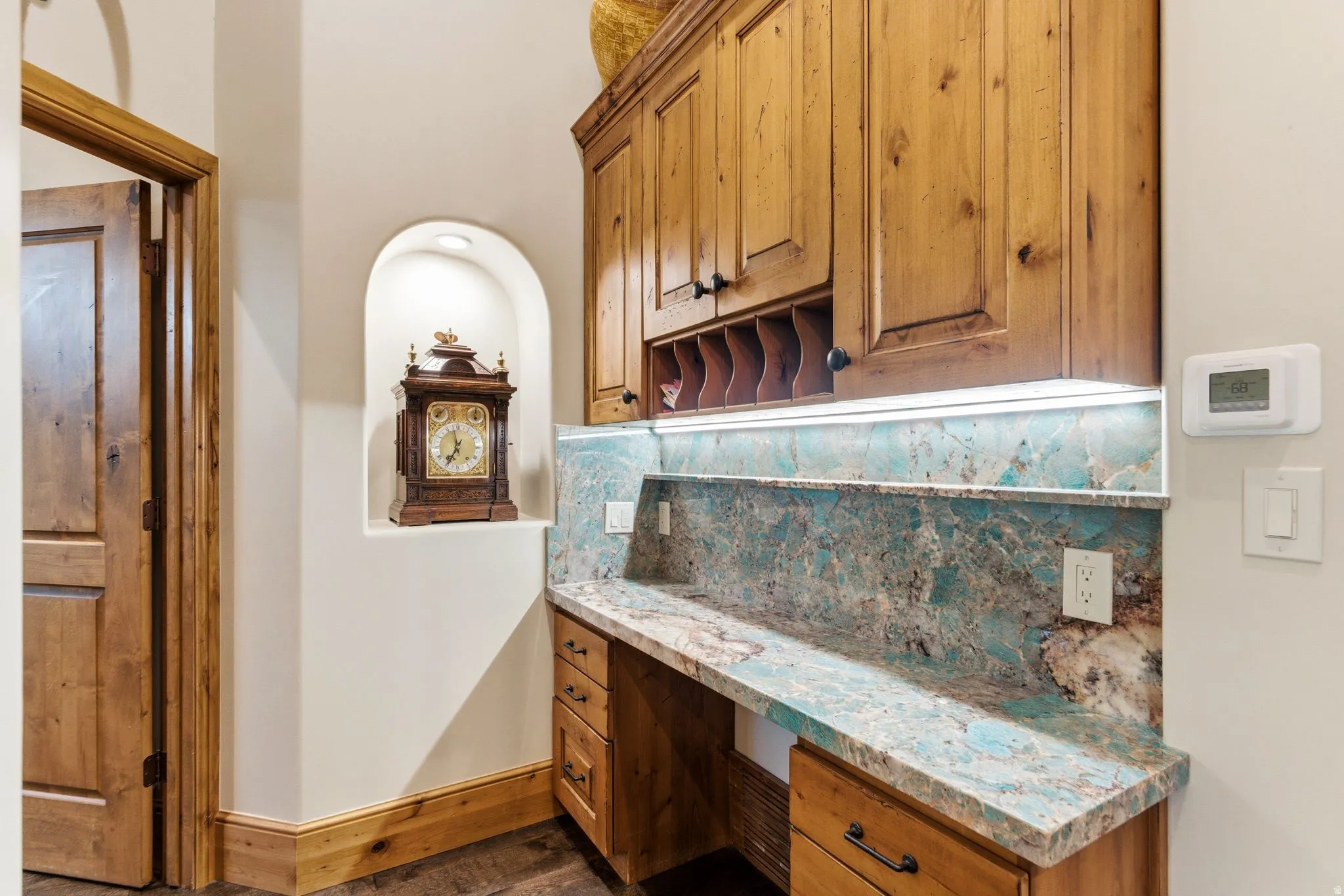 Built-in desk featuring a vibrant natural stone countertop and backsplash