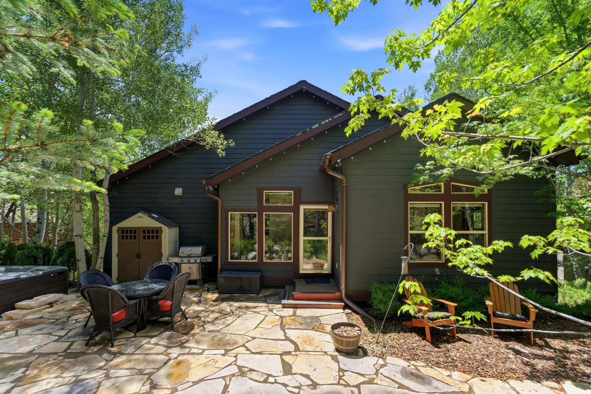 Exterior with dark siding and contrasting trim, featuring multiple windows