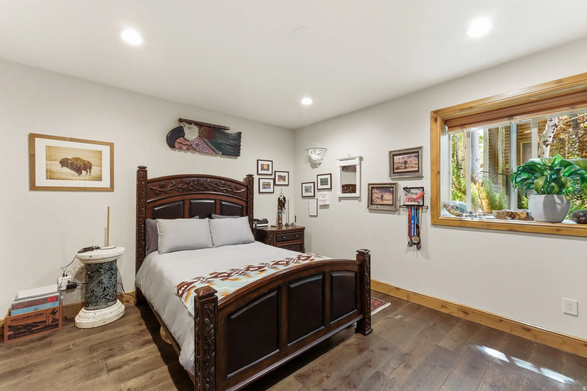 Bedroom featuring recessed lighting, wood-finish flooring, and a large window with natural wood trim