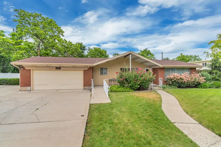 Single-story residence featuring brick and siding exterior, an attached garage, and a concrete driveway