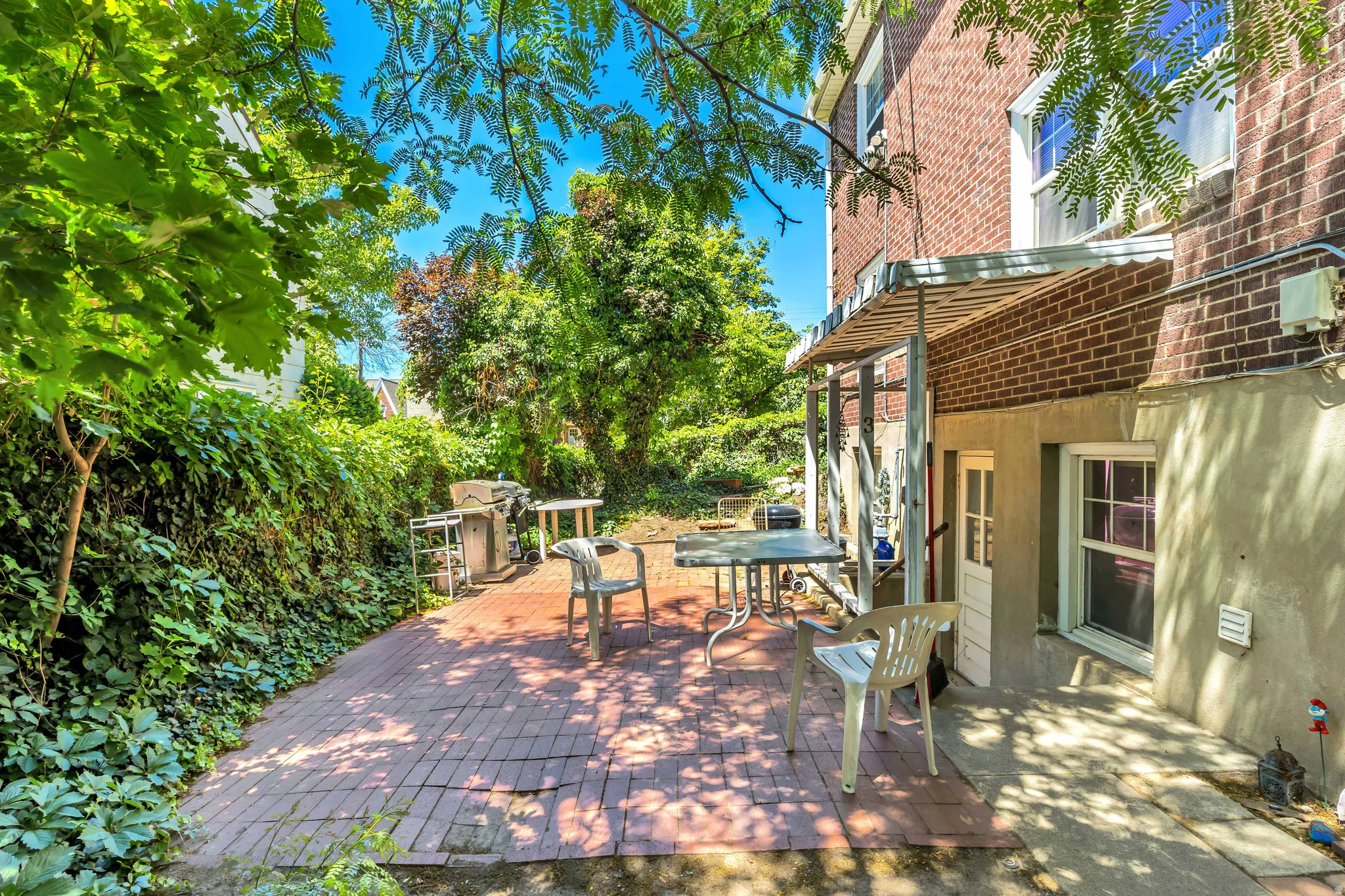 Unit 3 Brick patio area featuring a metal awning and an exterior door