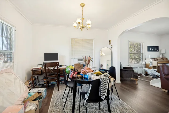 Unit 2  Bright interior space featuring wood-finish flooring, white walls, and a decorative archway