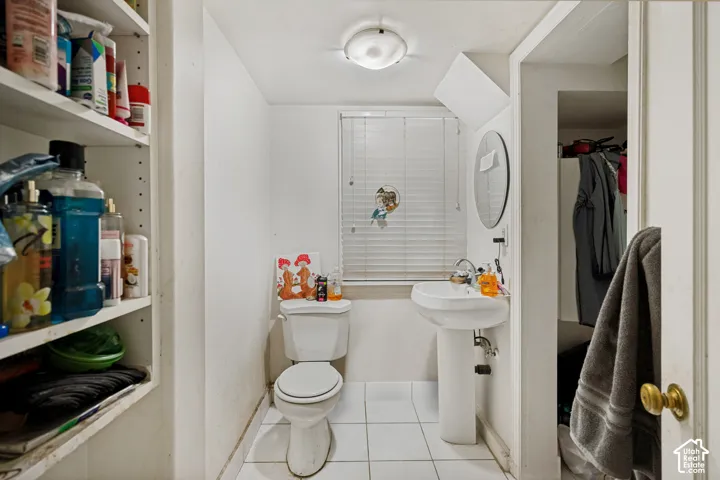 Unit 3  Bathroom featuring a pedestal sink, white toilet, and tile flooring