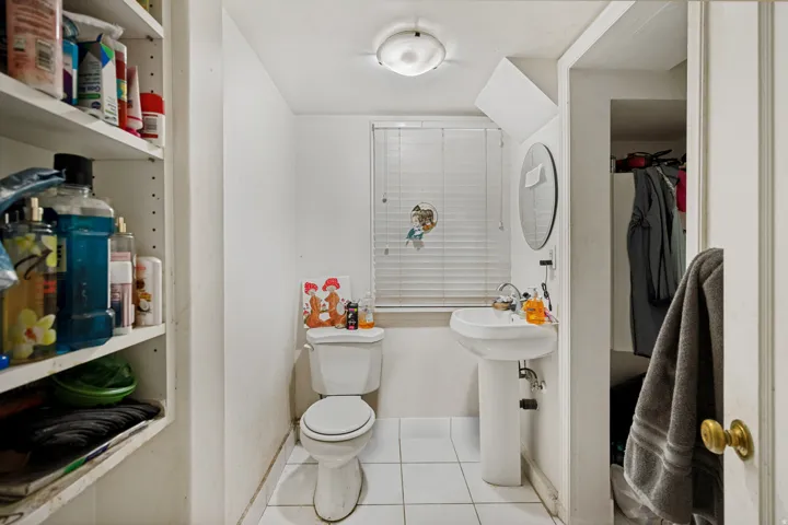 Unit 3  Bathroom featuring a pedestal sink, white toilet, and tile flooring