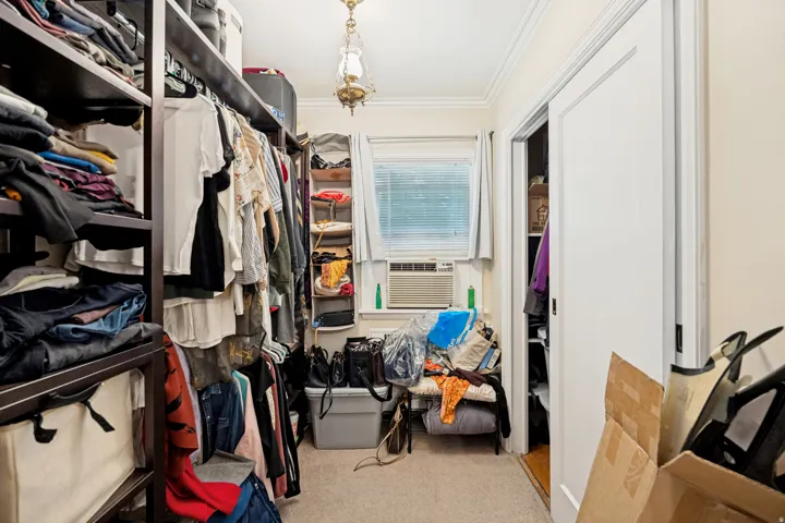 Unit 1 Custom closet system featuring dark wood-finish shelving and hanging rods