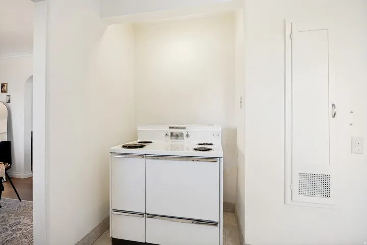Unit 2 White electric range with four burners, integrated controls, and a built-in oven set within an alcove