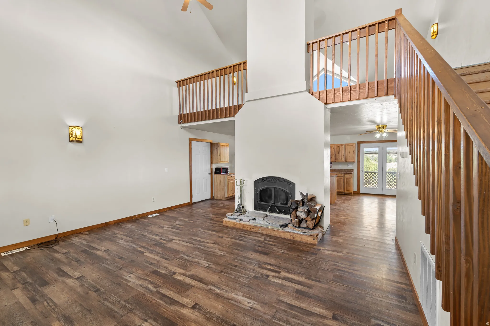 Looking from the front door through to the kitchen and garage door to the top left and the dinning room in the top right and the loft above.