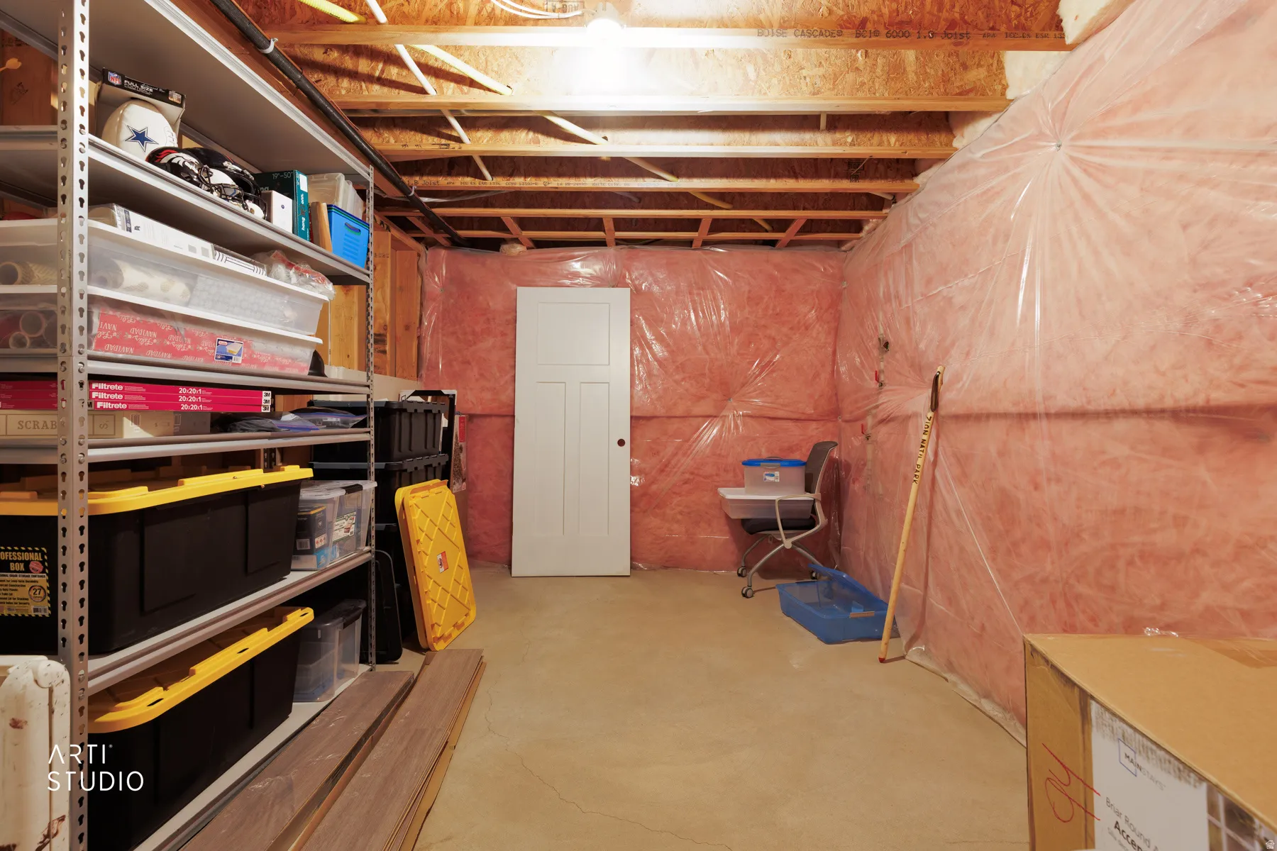 Basement area featuring exposed wood ceiling joists and subfloor, a concrete floor, and insulated walls with a vapor barrier