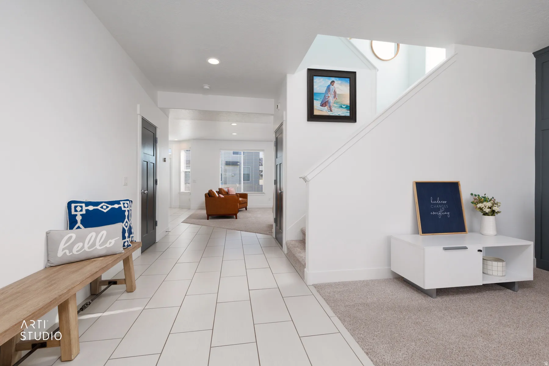Entryway featuring large format tile flooring, a carpeted staircase, recessed lighting, and a built-in storage cabinet