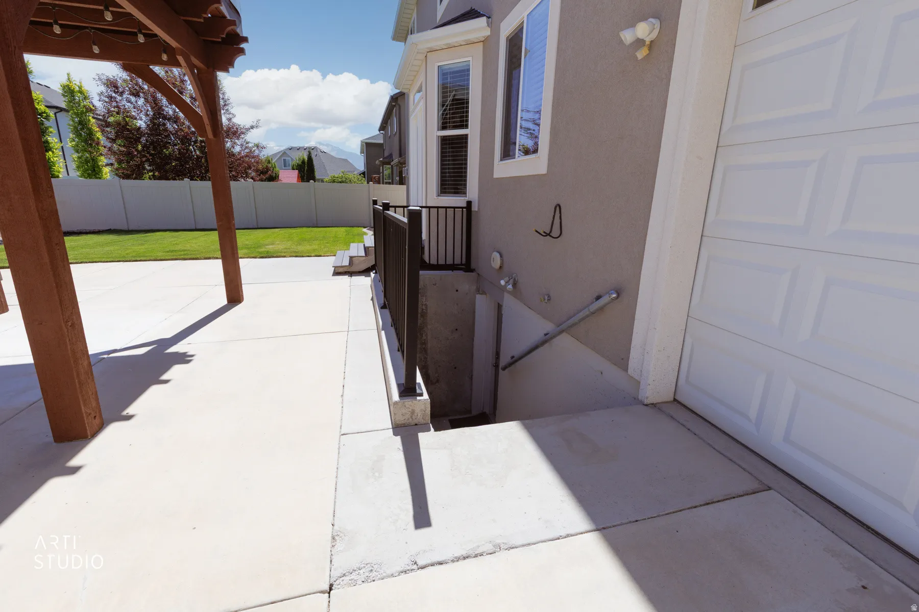 Patio area featuring a wood pergola and concrete paving