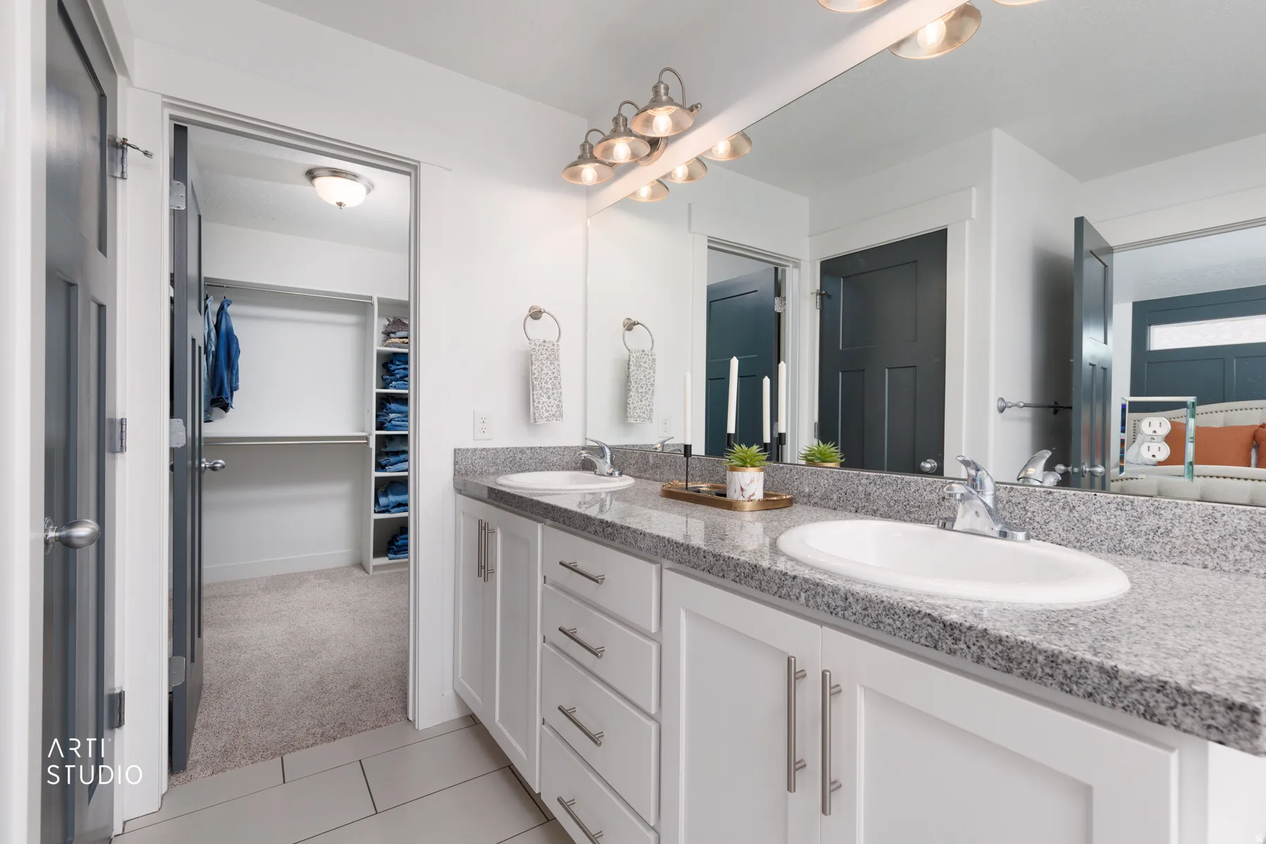 Double vanity with white cabinetry and chrome hardware, granite-finish countertops, and under-mount sinks