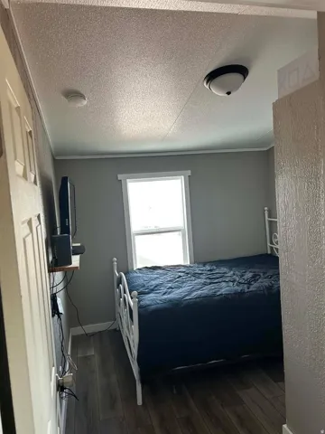 Interior room featuring wood-finish flooring, a white trim window, and a ceiling-mounted light fixture