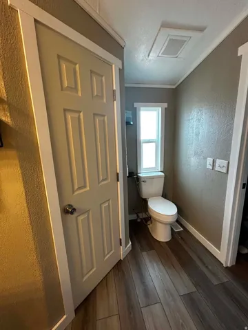 Master Bathroom featuring wood-finish flooring, a six-panel door, and a white framed window