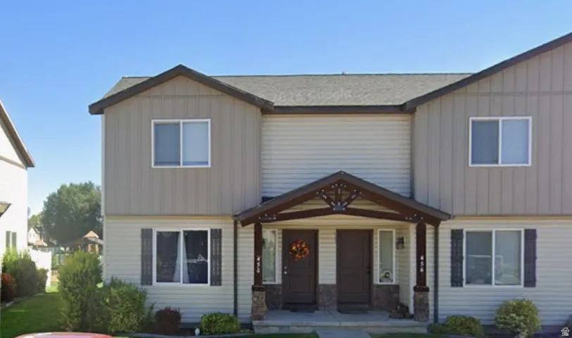 Duplex exterior featuring light-colored horizontal siding and contrasting vertical siding