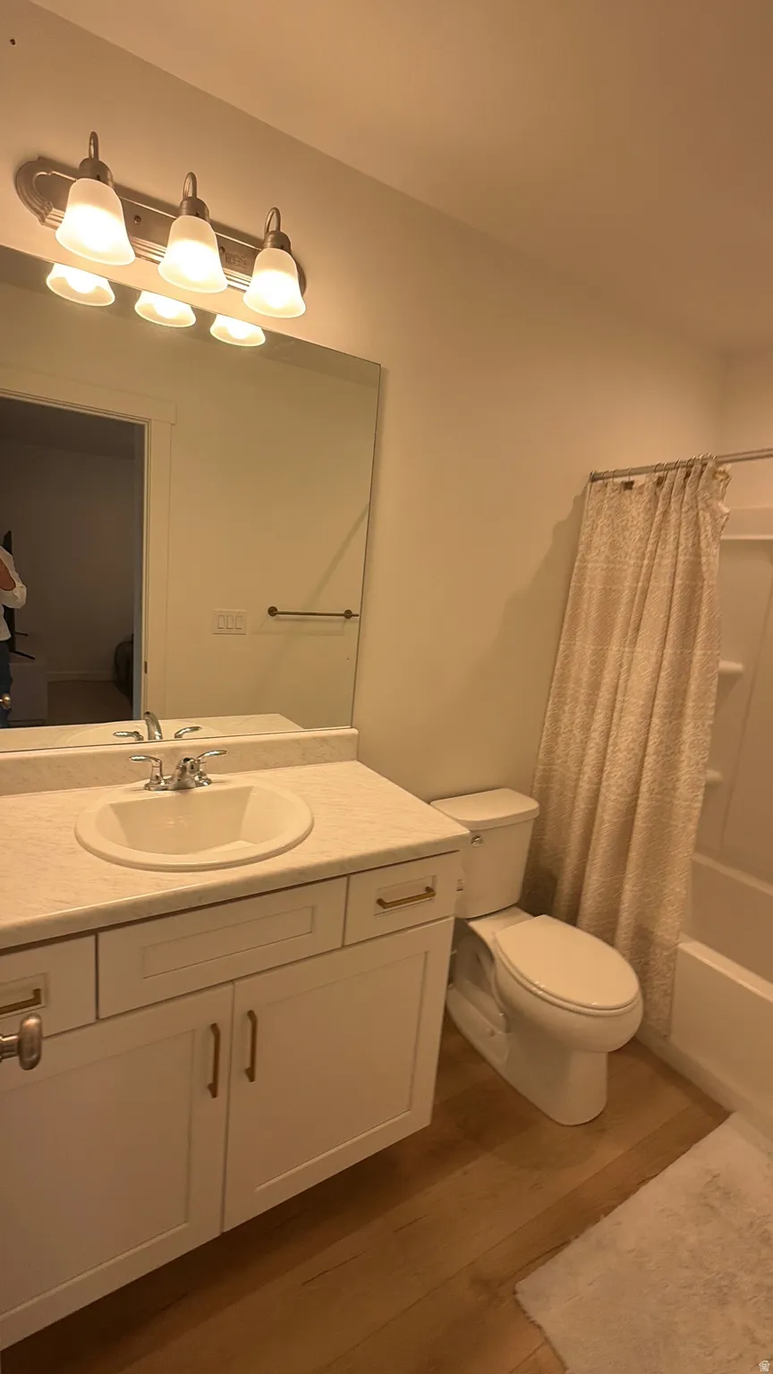 Bathroom featuring a white vanity with an undermount sink, a coordinating white toilet, and a white shower/tub combination