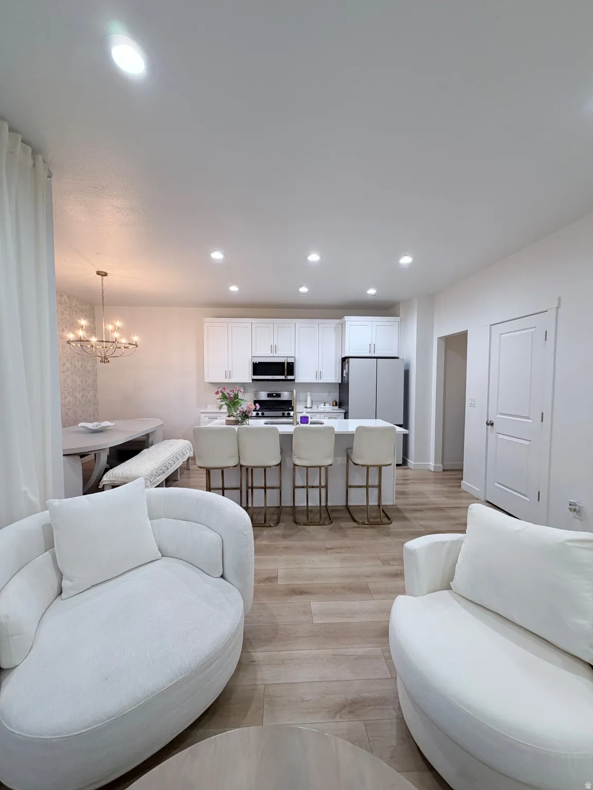 Open-concept living area featuring wood-finish flooring, recessed lighting, and white walls