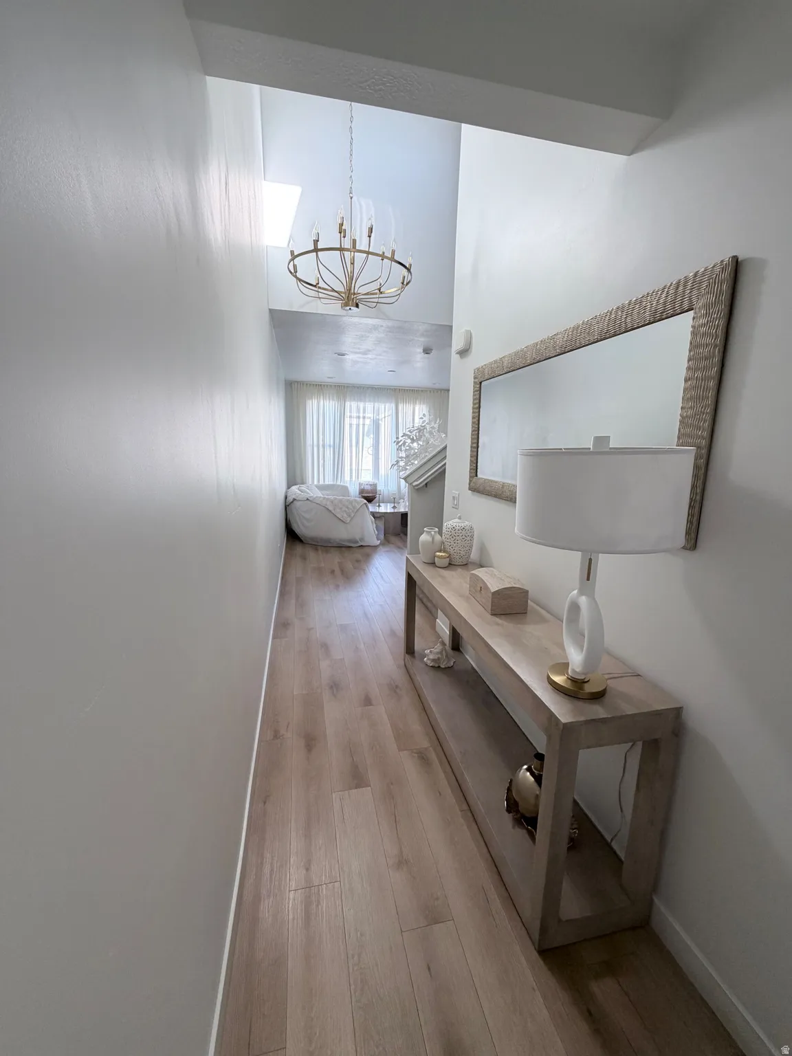 Bright hallway featuring high ceilings and wood-finish flooring