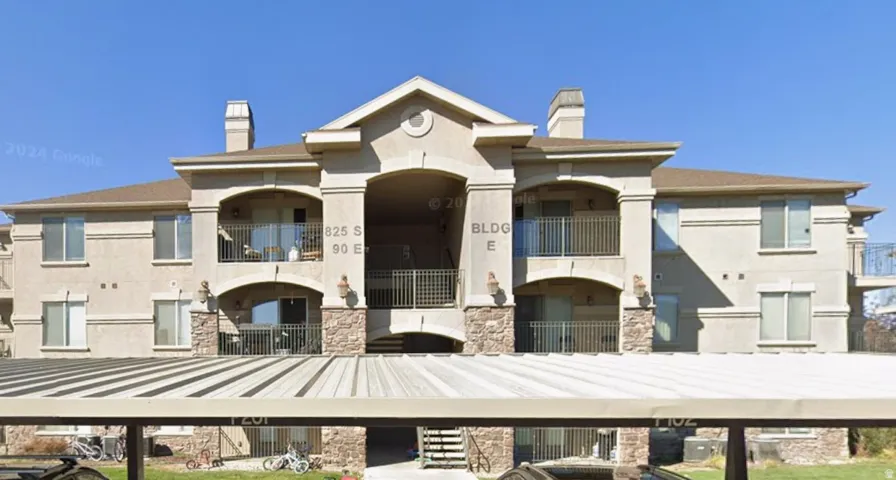 Multi-story stucco building with stone veneer accents