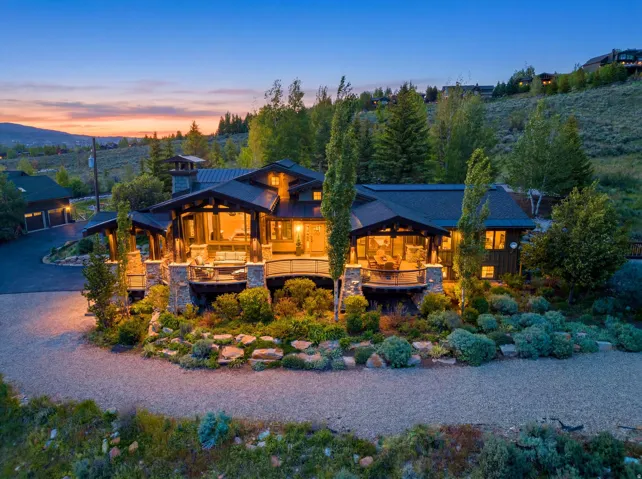 Craftsman-style residence with a dark-pitched roof and stone-clad foundation