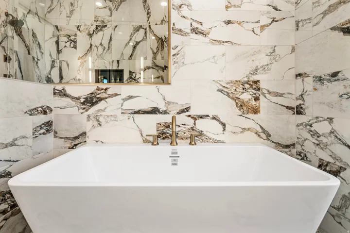 Freestanding soaking tub with gold-tone fixtures