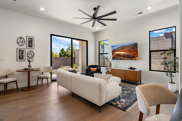 Open-concept living area with light wood-finish flooring, recessed lighting, and a modern ceiling fan