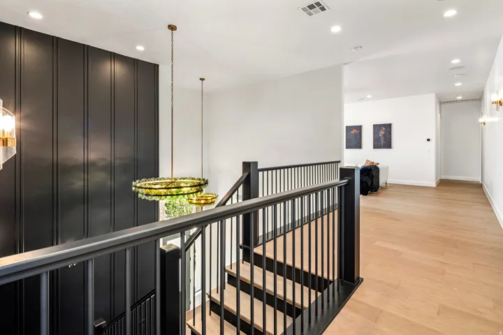 Staircase featuring dark wood-finish newel posts and railings with vertical balusters