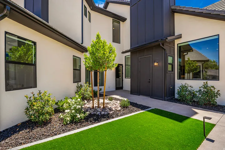 Modern exterior showcasing a dark vertical panel accent, white stucco, and black window frames