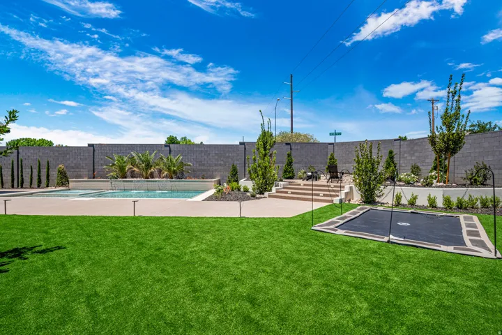 Expansive artificial turf lawn with an in-ground trampoline