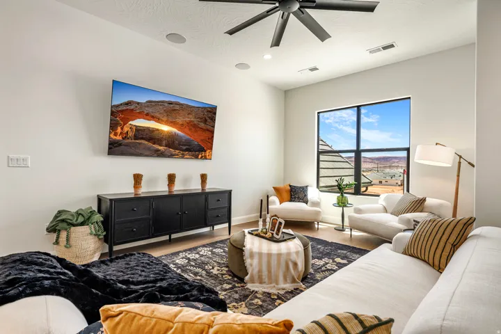 Spacious living area featuring a large picture window, high ceilings, recessed lighting, and wood-finish flooring