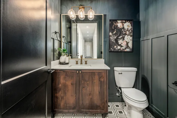 Vanity featuring a white countertop, brass-finish faucet, and coordinating overhead light fixture