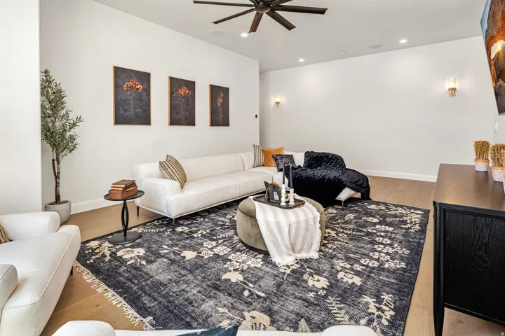 Spacious room featuring light wood-finish flooring, recessed lighting, and a modern ceiling fan