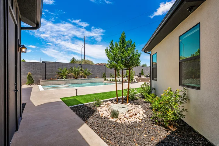 Expansive backyard featuring a rectangular swimming pool, integrated spa, and a concrete patio