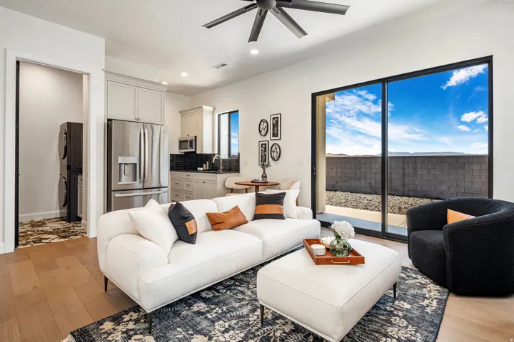 Open-concept living area featuring wood-finish flooring, a contemporary ceiling fan, and a large sliding glass door