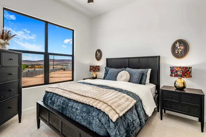 Expansive black-framed window offering distant desert and mountain scenery