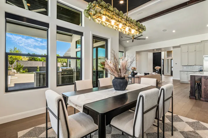 Dining area with expansive windows, a decorative chandelier, and wood-finish flooring