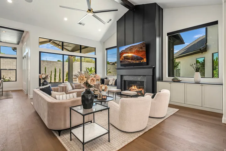 Living area featuring vaulted ceilings, a contemporary ceiling fan, and extensive wood-finish flooring