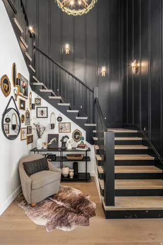 Stairwell featuring light wood-finish treads and black risers, complemented by a black balustrade