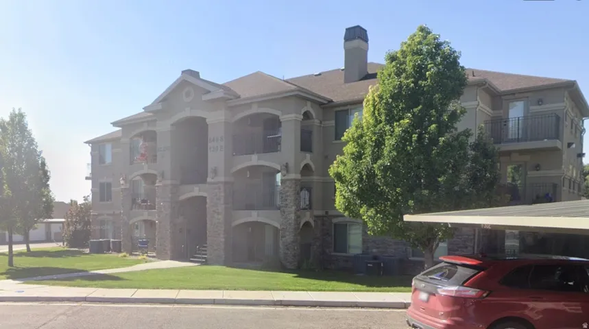 Multi-story residential building featuring a stucco and stone veneer exterior