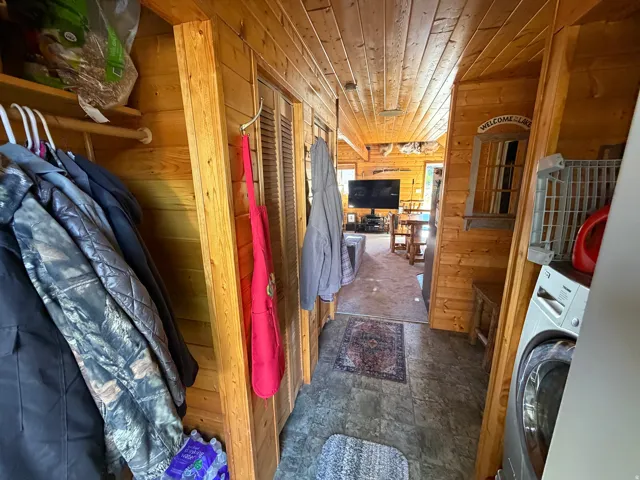 Hallway featuring wood-paneled walls and ceiling, providing a rustic aesthetic