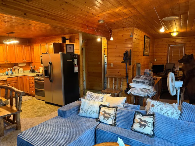 Open-concept living space with extensive wood paneling and wood-finish flooring