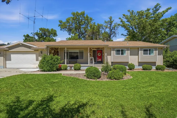 Ranch-style residence featuring a combination of brick and siding, a covered front porch, and an attached two-car garage