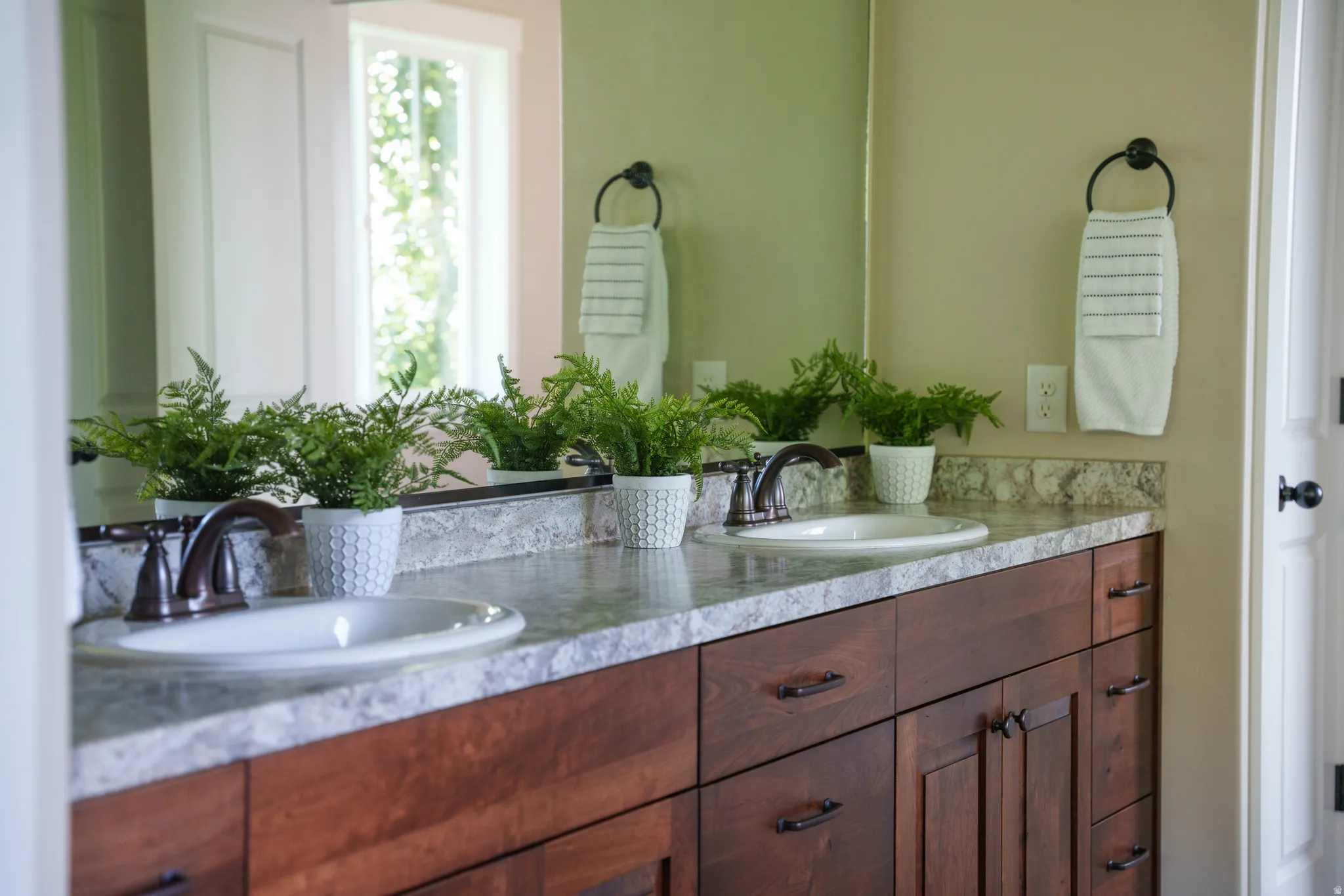 Double vanity featuring stone-finish countertops, undermount sinks, and oil-rubbed bronze faucets