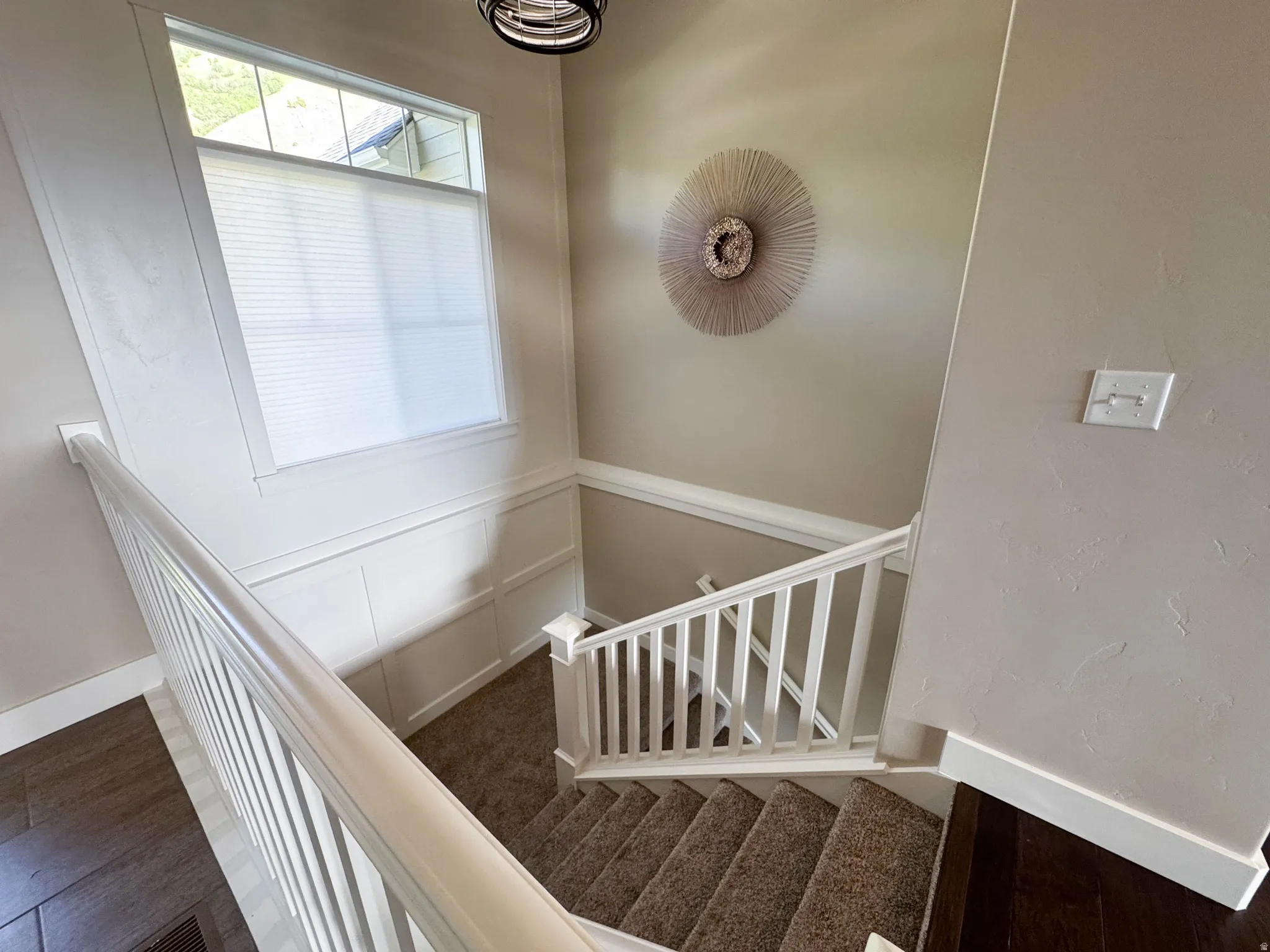 Carpeted staircase with white balusters and handrail