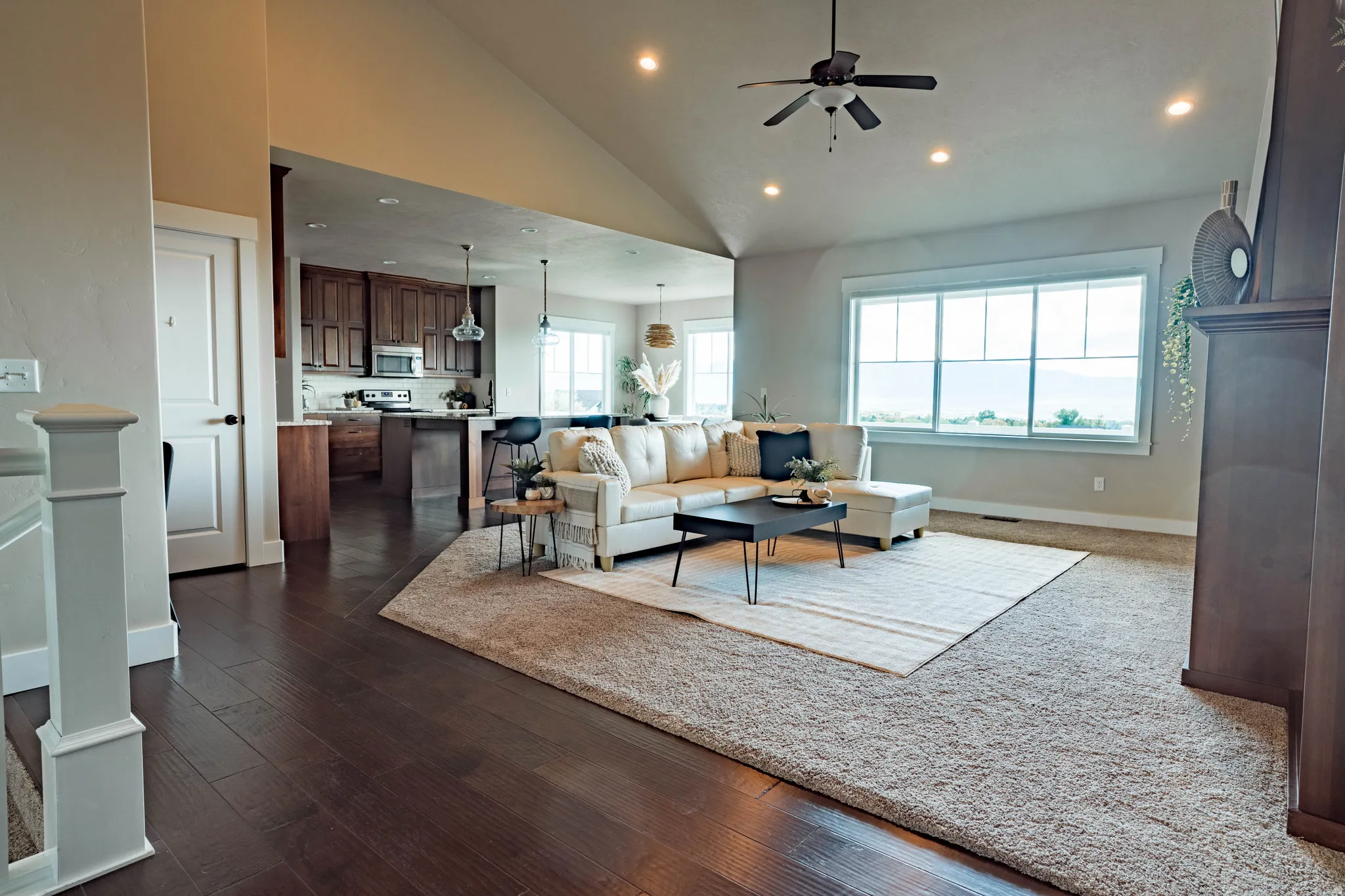 Open-concept living space with a vaulted ceiling, recessed lighting, and a ceiling fan