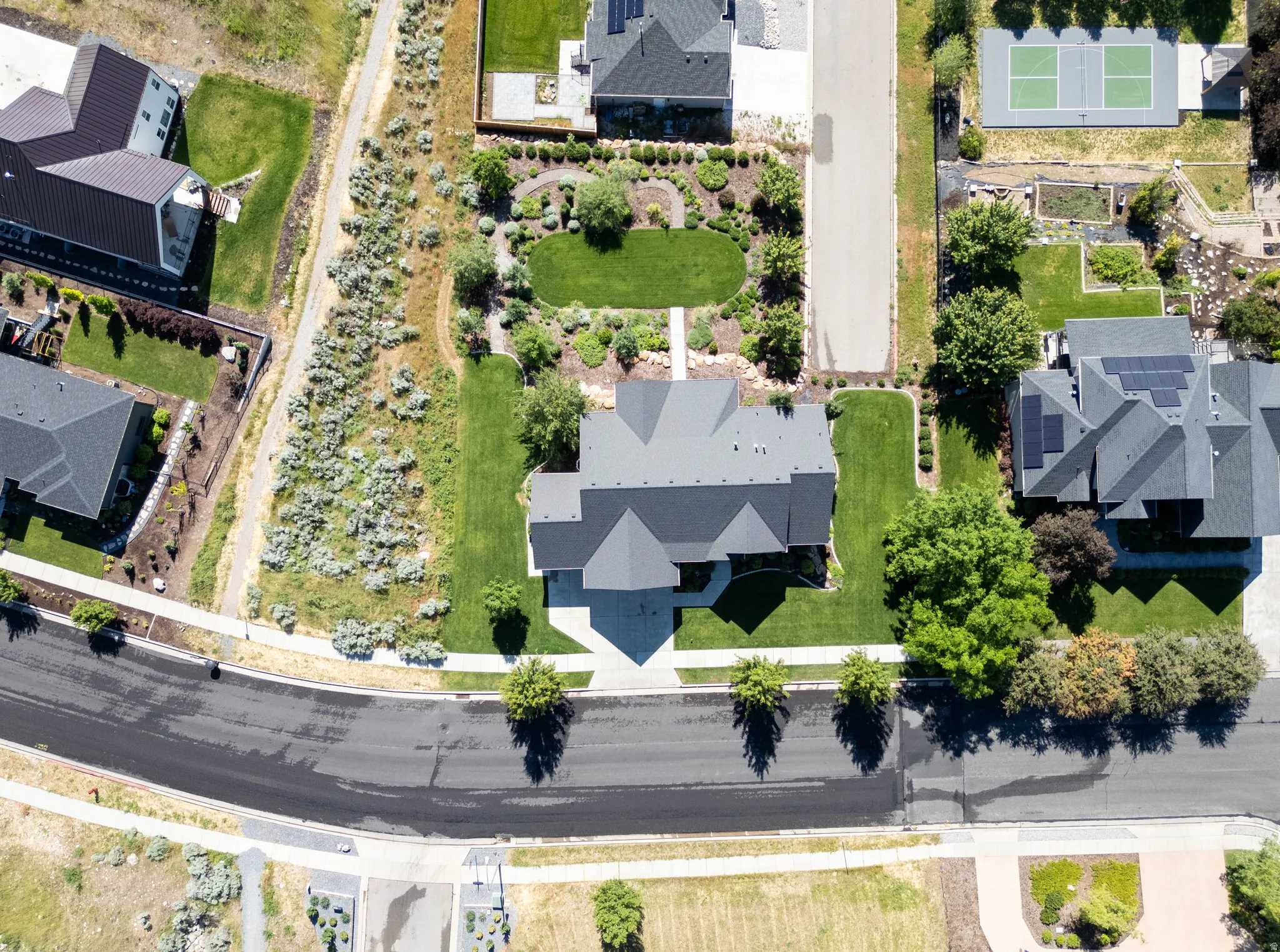 Aerial perspective showcasing a residential property with a multi-gabled roof and a paved driveway