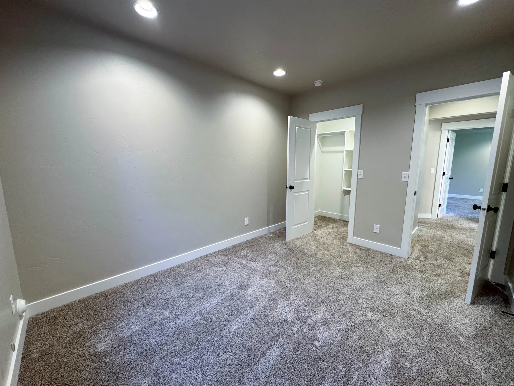 Neutral-toned room featuring plush carpeting, recessed lighting, and white trim
