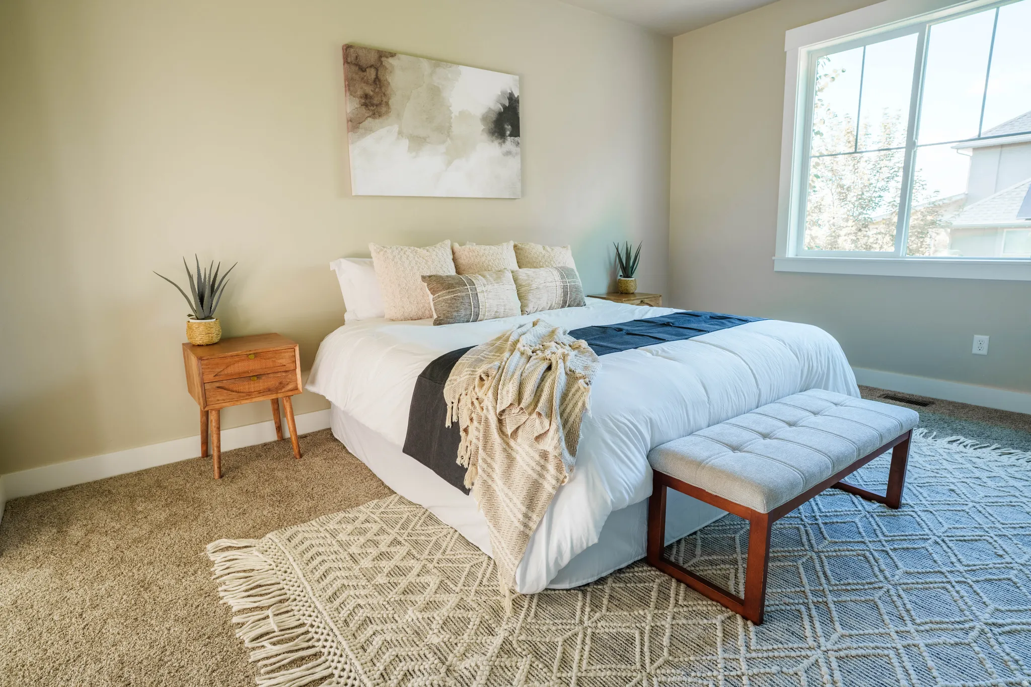 Warm neutral wall color, plush carpeting, and large windows with white trim